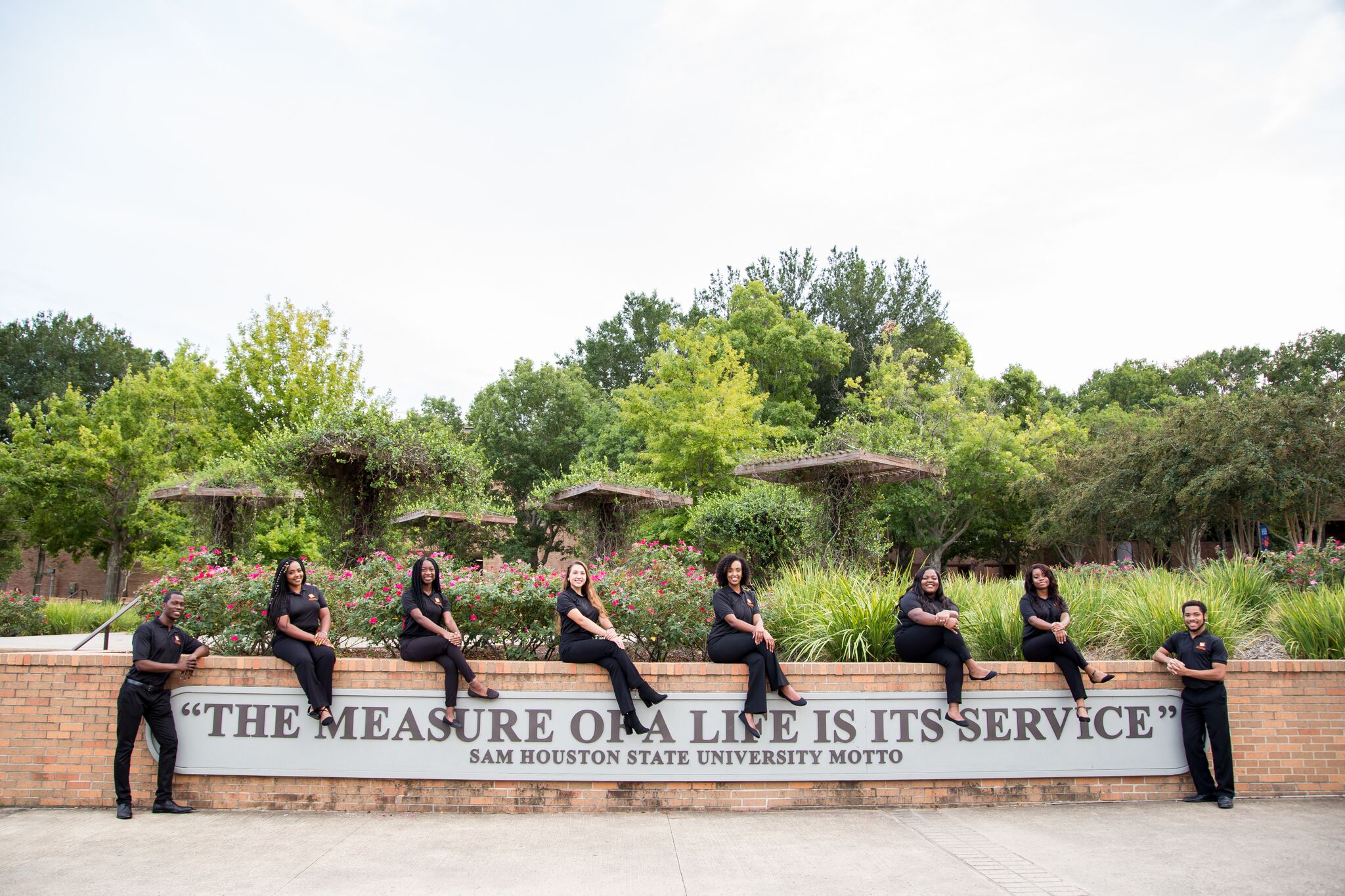 The Diversity Council poses on on the The Measure of a Life Is Its Service sign in the middle of campus.